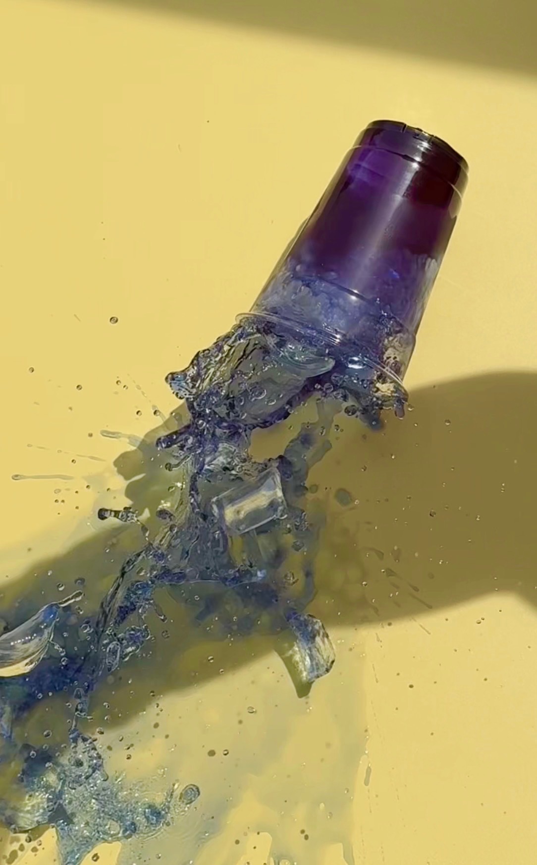 Blue bottle splashing on a yellow background