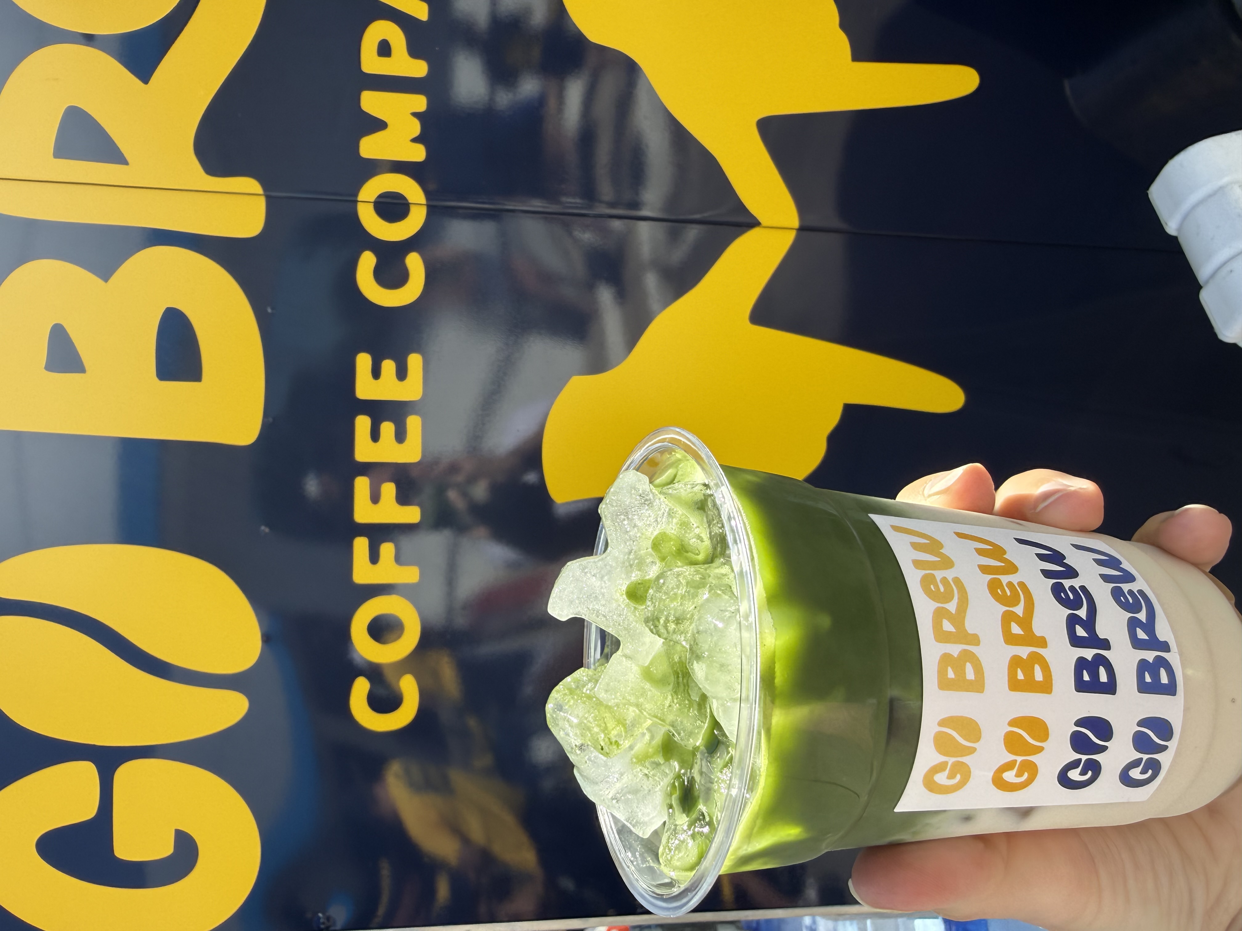 Iced matcha in front of the Go Brew trailer
